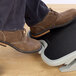 A person's feet on a Kensington SoleMate footrest.