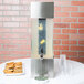 A Cal-Mil stainless steel beverage dispenser with infusion chamber on a table with drinks and cookies.