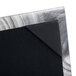 A close up of a black and silver Menu Solutions Alumitique metal corner.