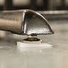 A Wobble Wedge on a table with a shiny metal surface and a screw on it.