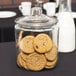 An Anchor Hocking glass jar filled with cookies.