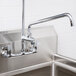 An Equip by T&S add-on faucet installed on a stainless steel sink.