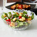 A salad in a clear Arcoroc glass bowl.