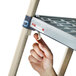 A hand assembling a MetroMax Q shelving unit with a metal ladder.