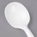 A close up of a Dart white plastic soup spoon with a white handle.