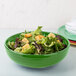 A green Fiesta china bowl filled with salad.