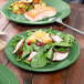 A Fiesta® luncheon plate with salad, fish, and a fork on a table.