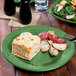 A green Fiesta® dinner plate with lasagna and salad on a table.