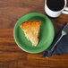 A slice of pie on a Fiesta® Meadow appetizer plate next to a cup of coffee.