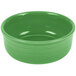 A green bowl with a white interior and a handle.