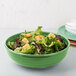 A Fiesta china bistro bowl filled with salad on a table.