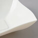 A Fineline ivory plastic serving bowl with a square shape and curved edges.
