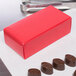 A red 1/2 lb. candy box with chocolates on a white surface.
