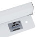 An Advance Tabco aluminum wall mounted ticket holder on a white wall.