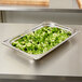 A Vollrath Miramar rectangular food pan on a counter filled with broccoli.