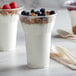 A 15 oz. PET parfait cup filled with yogurt, granola, and berries with a spoon.