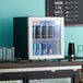 A Galaxy black countertop display refrigerator with cans of energy drinks.