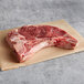 A raw Warrington Farm Meats T-Bone Steak on a piece of paper.