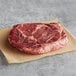A raw Warrington Farm Meats Delmonico steak on a piece of paper.