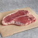 A piece of raw Warrington Farm Meats Porterhouse steak on a paper.