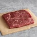 A piece of Warrington Farm Meats raw flat iron steak on a piece of paper.