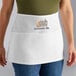 A woman wearing a white Choice apron with the words "custom me" on it.