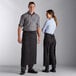 A man and woman wearing Choice black and white pinstripe bistro aprons.