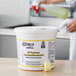 A white bucket with yellow text holding yellow Noble Chemical QuikPacks.