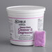 A white tub of Noble Chemical heavy duty cleaner and degreaser packs with purple labels next to a white bucket with purple powder.
