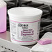 A white bucket of Noble Chemical QuikPacks Heavy Duty Cleaner and Degreaser on a professional kitchen counter.