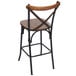 A BFM Seating Henry rustic metal counter height stool with a wooden back and seat.