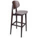 A BFM Seating Emma dark walnut bar height chair with a wooden seat and backrest.