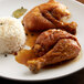 A plate with rice and chicken seasoned with Regal Adobo seasoning on a table.