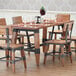 A Lancaster Table & Seating wooden trestle table base for a dining area table with wine glasses and chairs.