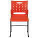 An orange plastic Flash Furniture stack chair with air-vent back.