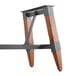 A Lancaster Table & Seating wooden trestle table base with metal accents.