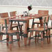 A Lancaster Table & Seating wooden trestle table base on a wooden table in a restaurant dining area.