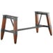 A Lancaster Table & Seating rustic industrial wooden trestle table base with metal legs and wood accents.