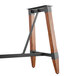 A Lancaster Table & Seating wooden trestle table base with metal accents.