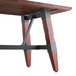 A Lancaster Table & Seating solid wood table with metal legs.