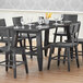 A Lancaster Table & Seating live edge dining table with chairs and wine glasses on it.