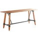 A Lancaster Table & Seating wooden bar height table with live edge and legs.