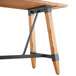 A Lancaster Table & Seating wooden bar height table with metal legs.