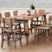 A Lancaster Table & Seating solid wood dining table with wooden trestle legs.
