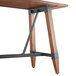 A Lancaster Table & Seating solid wood bar height trestle table with metal legs.