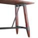 A Lancaster Table & Seating live edge wood table with metal trestle legs.
