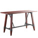 A Lancaster Table & Seating wooden bar height table with legs.