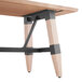 A wooden Lancaster Table & Seating live edge dining table with black trestle legs.