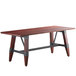 A Lancaster Table & Seating wooden table with metal legs and a dark wood top.