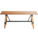 A Lancaster Table & Seating wooden table with legs and a live edge top.